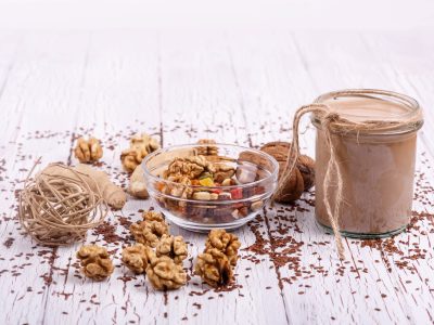 healthy brown smoothie with walnut and candied fruits lie on the table